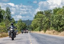 Hommes conduisant leurs motos d'aventure sur la route de campagne au Cambodge — Photo de stock