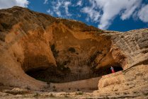 Eine Frau wandert unter einem malerischen Pfad unter einem riesigen Überhang Höhlen von Zaen, Zaen Dorf, Campo de San Juan, Moratalla, Regin de Murcia, Espaa — Stockfoto