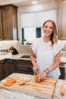 Schöne Frau schneidet Gemüse auf dem Küchentisch — Stockfoto