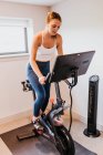 Jeune femme faisant de l'exercice avec des haltères dans la salle de gym — Photo de stock