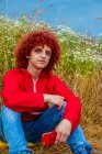 Junger Kerl mit rotgelockten Haaren in rotem 80er-Jahre-Sportanzug und Handy im Freien — Stockfoto