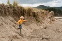 Blonde haired child running down sand dune in New Zealand — Stock Photo