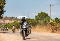 Чоловіки їздять на своїх пригодницьких мотоциклах по сільській дорозі в Камбоджі. — стокове фото