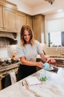 Young woman cooking breakfast in kitchen — Stock Photo