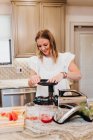 Giovane donna cucina cibo in cucina — Foto stock