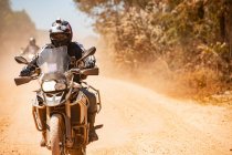 Uomo in sella alla sua avventura moto su strada polverosa in Cambogia — Foto stock