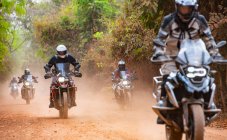 Group of men riding their adventure motorbike on dirt road in Cambodia — Stock Photo