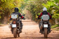 Deux hommes conduisant leur moto d'aventure sur un chemin de terre au Cambodge — Photo de stock