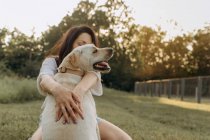Bela feliz jovem mulher com seu cão ao ar livre — Fotografia de Stock
