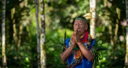 Cofan chaman indigène priant avec les mains jointes dans la forêt amazonienne — Photo de stock