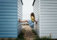 Girl playing at beach huts at the seaside in the UK — Stock Photo