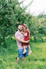 Un padre e sua figlia in piedi accanto ai meli in estate — Foto stock
