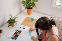 Frau malt zu Hause in ihrem Atelier mit Aquarellen — Stockfoto