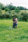 Чоловік і жінка поділяють поцілунок на лузі серед яблунь — стокове фото