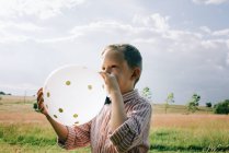 Ragazzo in camicia e papillon far saltare in aria un palloncino di nozze — Foto stock