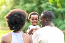 African couple walking with their daughter in the park — Stock Photo