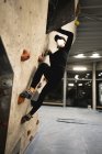 Chica escalando en un gimnasio de escalada - foto de stock
