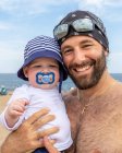 Father holding baby boy at the beach. — Stock Photo