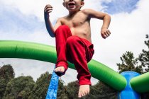 Garçon sautant sur une aire de jeux — Photo de stock