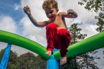Хлопчик стрибає на дитячому майданчику — стокове фото