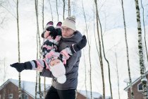 Der Vater mit der Tochter beim Spaziergang im Winterdorf. — Stockfoto