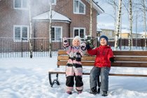 Двоє дітей весело гуляють в зимовому селі . — стокове фото