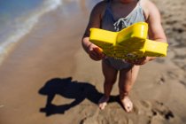 Baby boy playing with toy star in the sea. — Stock Photo