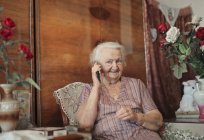 Retrato de senhora idosa em sua casa enquanto telefona — Fotografia de Stock