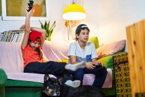 Дети вместе играют в видеоигры в гостиной — стоковое фото