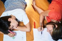 Niños dibujando divirtiéndose en casa - foto de stock