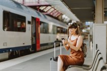 Femme avec téléphone portable et train — Photo de stock