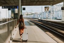Junge Frau mit Gepäck und Rucksack am Bahnhof — Stockfoto