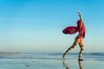 Jeune femme pratiquant le yoga sur la plage — Photo de stock