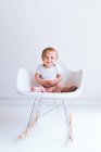 Bonito pequeno bebê menino sentado na cadeira no quarto — Fotografia de Stock