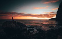 Donna con zaino sulla costa del mare — Foto stock