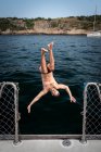Hombre saltando de velero en el océano en Río de Janeiro, Brasil - foto de stock