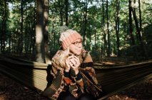 Jovem mulher em um chapéu e um lenço na floresta — Fotografia de Stock