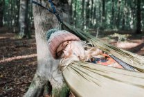 Красива жінка сидить в гамаку в лісі — стокове фото
