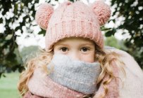 Portrait d'une jolie petite fille en bonnet tricoté et écharpe — Photo de stock