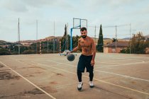 Giovane ragazzo formazione da solo su un campo da basket — Foto stock