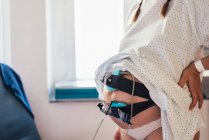 Belly of pregnant woman connected to pregnancy monitoring. Preparation to childbirth. Healthy pregnancy concept. — Stock Photo