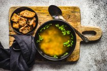 Hühnerbrühe in einer Schüssel serviert und mit frischen grünen Zwiebeln und frittiertem Brot — Stockfoto
