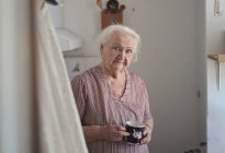Retrato de anciana en su cocina - foto de stock