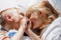 Children in the morning sun in bed — Stock Photo