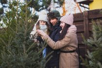 Familie wählt gemeinsam den Weihnachtsbaum für die Abendfeier im Urlaub — Stockfoto