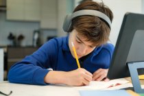 Online-Fernunterricht. Ein Schuljunge lernt zu Hause und macht Hausaufgaben. Ein Fernstudium zu Hause. — Stockfoto