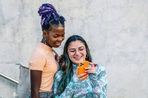 Moda multiétnica lesbianas novias tomando selfie en smartphone - foto de stock