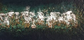 Vista aérea das ondas do oceano e rochas na água — Fotografia de Stock