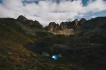 Tenda illuminata contro aspre montagne e lago, Pirenei. — Foto stock