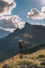 Young man wearing cap and looking high up the objective against cloudy sky, Pyrenees, Aragon, Spain — Stock Photo